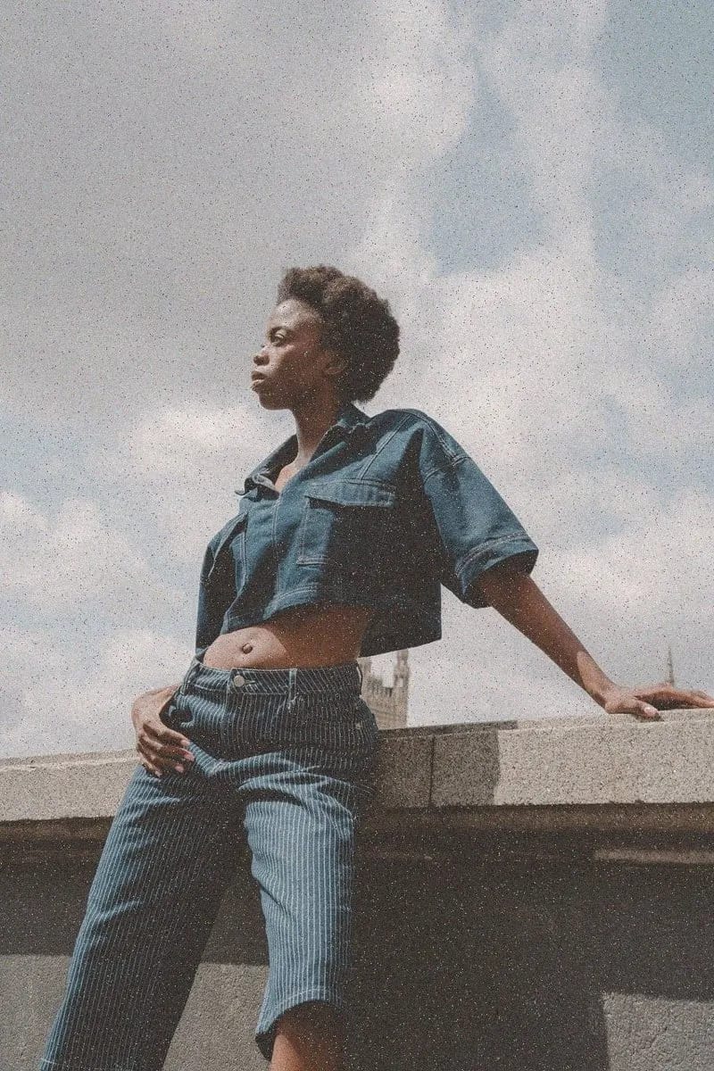 Person in a denim jacket against a bright wall